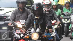 Seorang warga mengendarai motor bersama dua ekor monyet peliharaanya di kawasan Senayan, Jakarta, Kamis (1/12). Kemampuannya beradaptasi membuat monyet ekor panjang terbiasa dengan kehadiran manusia sehingga banyak dipelihara. (Liputan6.com/Helmi Affandi)
