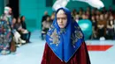 Seorang model dengan scarf menyerupai hijab di kepalanya menampilkan koleksi terbaru Gucci FW18 dalam Milan Fashion Week 2018, Rabu (21/2). Hadirnya model yang memakai scarf menyerupai hijab itu mencuri perhatian. (AP Photo/Antonio Calanni)