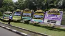 Warga mengambil gambar karangan bunga ucapan duka cita untuk Probosutedjo yang memenuhi Jalan Diponegoro, Jakarta, Senin (26/3). Probosutedjo meninggal dunia di RSCM Kencana Jakarta Pusat. (Liputan6.com/Arya Manggala)
