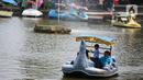 Wisatawan menaiki perahu saat mengunjungi TMII, Jakarta, Kamis (20/8/2020). Libur panjang yang bertepatan tahun baru islam di manfaatkan masyarakat bersama keluarga  berlibur ke sejumlah tempat wisata. (Liputan6.com/Faizal Fanani)