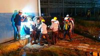 Karyawan PT Sari Dumai Oleo dan personel Polres Kota Dumai mengevakuasi korban kebakaran tangki. (Liputan6.com/M Syukur)