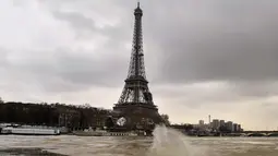 Menara Eiffel terlihat saat sungai Seine di Paris meluap, Prancis (6/1). Sungai Seine tidak mampu menampung debit air setelah hujan terjadi terus-menerus. (AFP Photo/Christophe Simon)