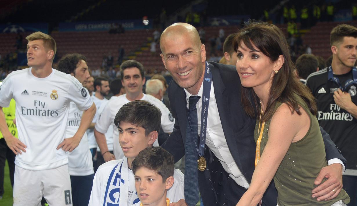 Zidane dan keluarga saat meraih trofi pertama Liga Champions bersama Real Madrid di San Siro Stadium, Milan, (29/5/2016). Zidane mundur dari kursi pelatih Madrid setelah meraih trofi Liga Champions tiga kali. (AFP/Filippo Montefort