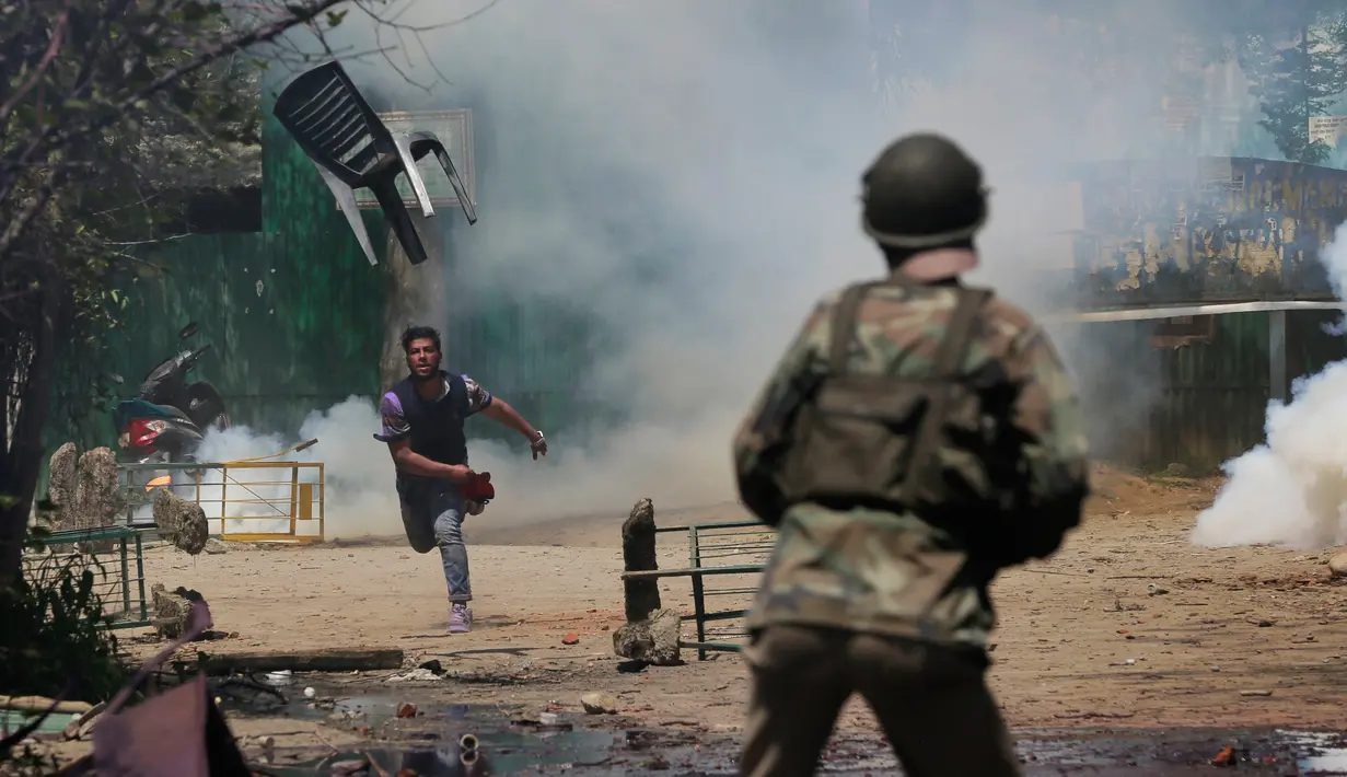 Mahasiswa di Kashmir bentrok dengan pasukan keamanan India di Srinagar, Kashmir, India,  Senin (17/4). Aksi Mahasiswa tersebut untuk memprotes razia polisi di sebuah perguruan tinggi. (AP Photo / Mukhtar Khan)
