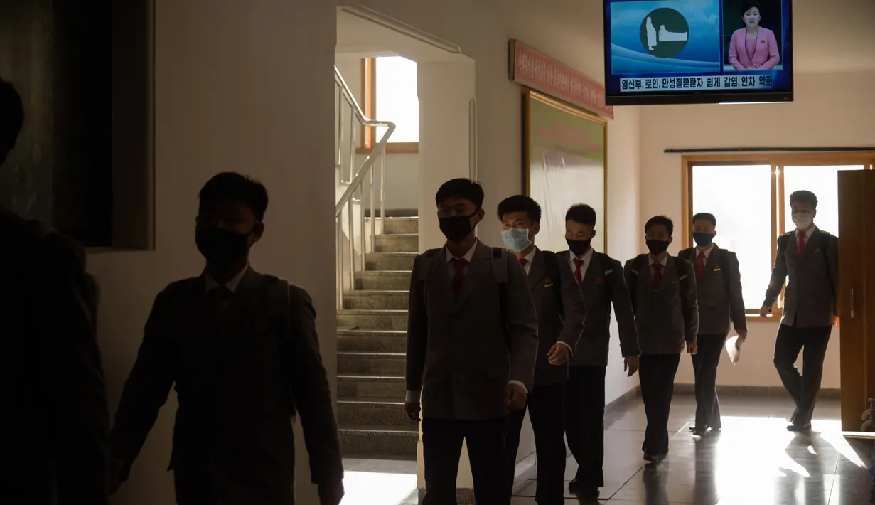 Mahasiswa berjalan dengan mengenakan masker sebagai upaya mencegah penyebaran pandemi Covid-19 di Universitas Kedokteran Pyongyang, Rabu (22/4/2020). Sejak pandemi itu muncul di China, Korea Utara menutup perbatasan dan mengkarantina ribuan warganya serta warga asing di negara itu. (KIM Won Jin/AFP)