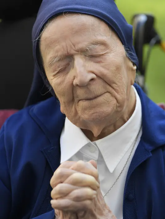 Lucile Randon atau Suster Andre, warga negara Prancis dan orang tertua di Eropa, berdoa di atas kursi roda, di Toulon, Rabu (10/2/2021). Suster Andre didapuk sebagai orang tertua kedua di dunia dan pertama di Eropa yang masih hidup menurut Gerontology Research Group. (NICOLAS TUCAT/AFP)