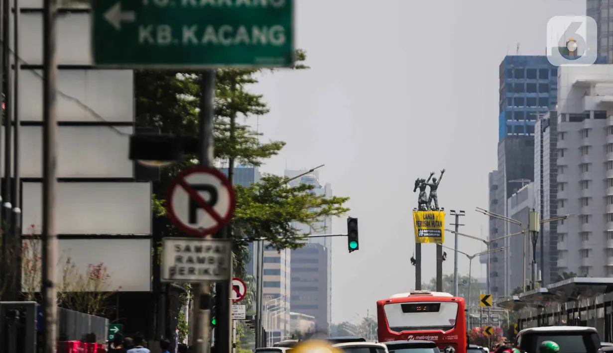 Sejumlah orang membentangkan spanduk di Patung Selamat Datang, Bundaran HI, Jakarta, Rabu (23/10/2019). Aksi ini dilakukan untuk menggalang kepedulian terhadap lingkungan Indonesia. (Liputan6.com/Faizal Fanani)