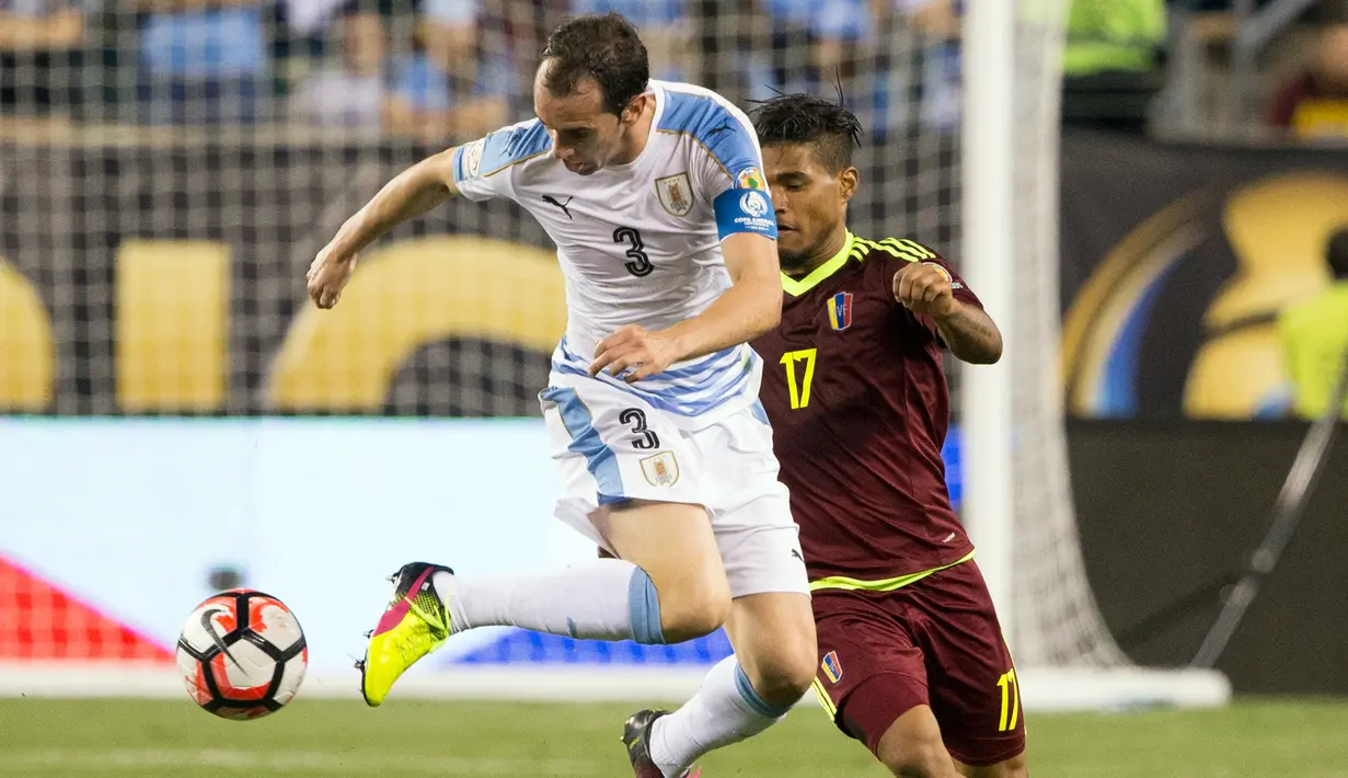 Bek Uruguay, Diego Godin berusaha mengontrol bola dari kawalan penyerang Venezuela, Josef Martinez pada Copa America  Centenario 2016 di Lincoln Financial Field, AS (10/6). Venezuela menang atas Uruguay 1-0. (Bill Streicher-USA TODAY Sports)