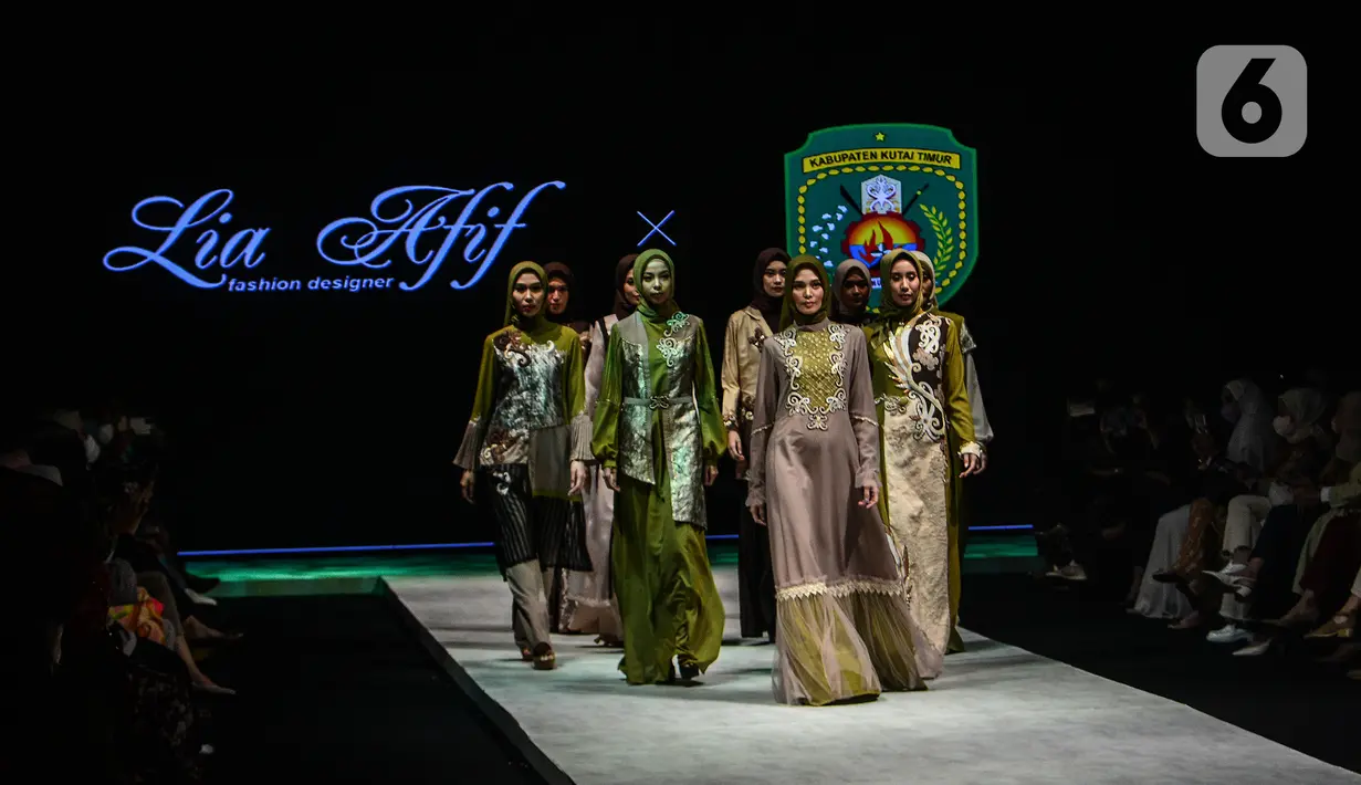 Model mengenakan busana kain rancangan karya LIA AFIF fashion desainer berkolaborasi dengan Pemkab Kutai Timur pada Indonesia Fashion Week 2022 di Jakarta Convention Center, Rabu (13/4/2022). Perhelatan Indonesia Fashion Week mengangkat tema "Magnificient Borneo". (Liputan6.com/JohanTallo)