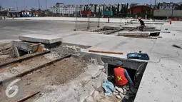 Pekerja membongkar rel kereta yang tertutup beton di Pelabuhan Tanjung Priok, Jakarta, Jumat (11/9/2015). Jalur kereta yang dibangun sejak zaman Belanda tersebut aktif bisa membantu keluar masuk barang di pelabuhan. (Liputan6.com/Gempur M Surya)