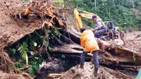 Petugas BPBD Lumajang dengan merahkan alat berat menyingkirkan matreal longsoran tanah yang menutup jalan penghubung Lumajang- Malang via Pronojiwo (Istimewa)