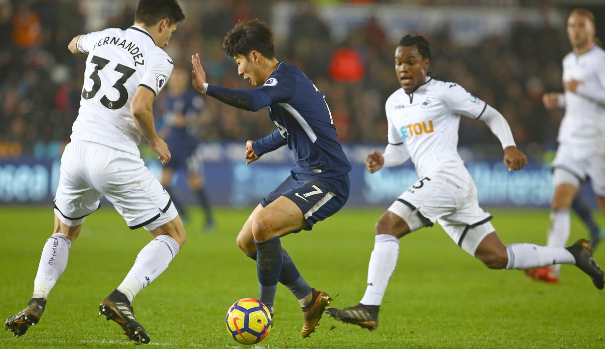 Pemain Tottenham, Son Heung-Min (tengah) berusaha melewati adangan dua pemain Swansea City  pada lanjutan Premier League di The Liberty Stadium, Swansea, (2/1/2018). Tottenham menang 2-0. (AFP/Geoff Caddick)