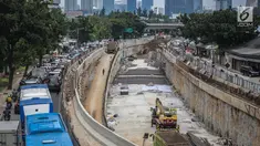 Sejumlah kendaraan melintas di samping proyek pembangunan underpass Mampang-Kuningan di kawasan Mampang, Jakarta, Rabu (27/12). Pengerjaan proyek yang kini telah mencapai 80 persen tersebut ditargetkan selesai pada April 2018. (Liputan6.com/Faizal Fanani)
