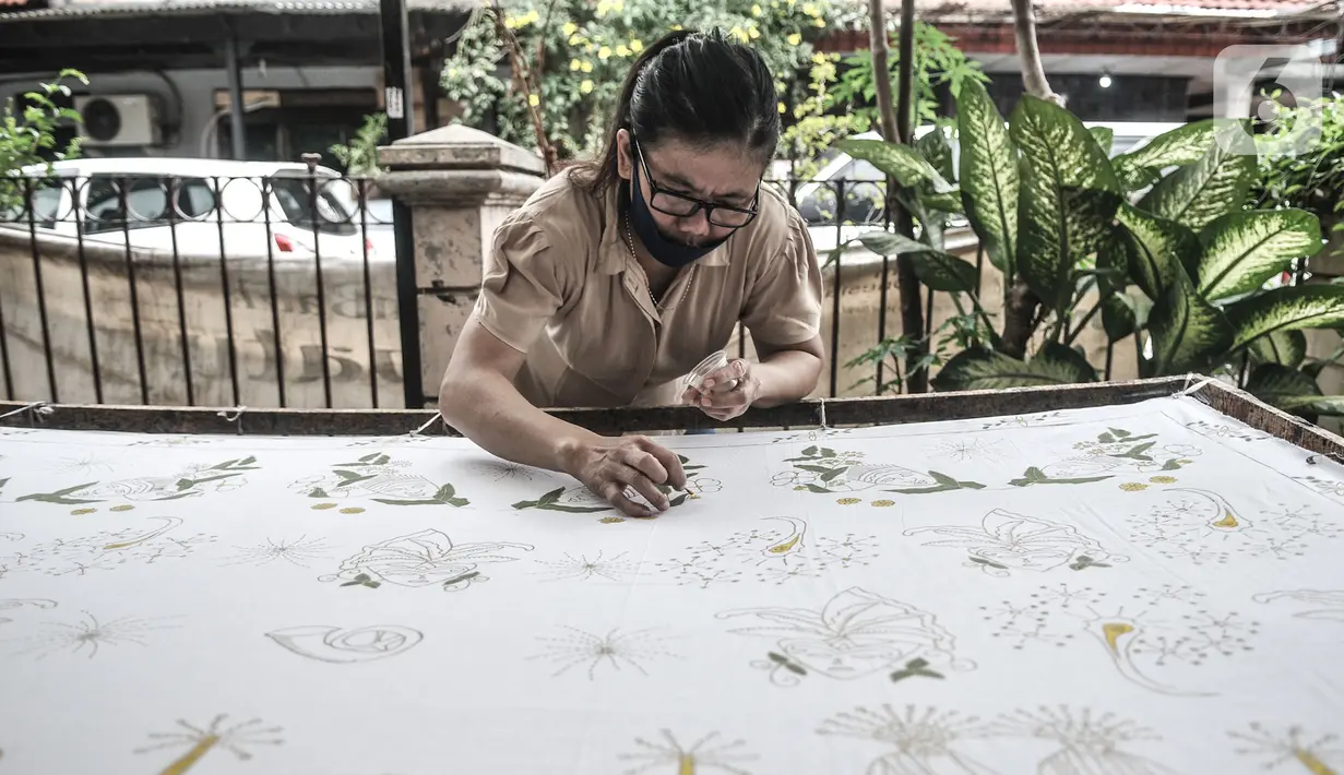 Pembatik disabilitas menyelesaikan karyanya di Rumah Batik Palbatu, Jakarta, Kamis (3/12/2020). Rumah Batik Palbatu mempercayakan kepada penyandang disabilitas binaannya untuk membuat kain batik, baik bercorak tradisional, temporer maupun perpaduan keduanya. (merdeka.com/Iqbal S. Nugroho)