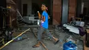 Seorang anak berjalan di antara puing-puing di sepanjang daerah pantai setelah gempa dan tsunami di Palu, Selasa (2/10). Data terbaru BNPB menunjukkan, korban tewas akibat tsunami dan gempa di Sulawesi Tengah sudah mencapai 1.347 orang. (AFP/Mohd RASFAN)