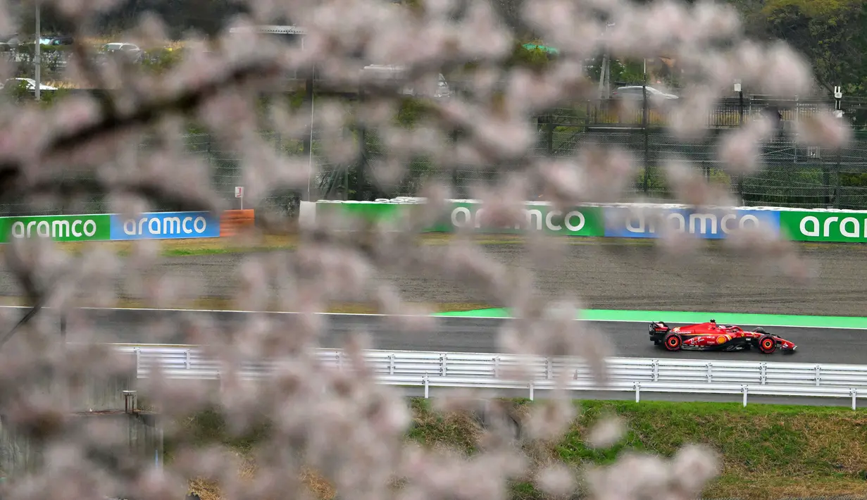 Pembalap Ferrari, Charles Leclerc terlihat melewati pohon sakura saat melakukan latihan bebas pertama (FP1) F1 GP Jepang 2024 di Sirkuit Suzuka, Jepang, Jumat (05/04/2024). (AFP/Yuichi Yamazaki)