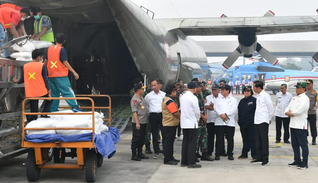 Presiden Joko Widodo (Jokowi) berbincang saat meninjau kesiapan operasional pesawat penyemai di Lanud Roesmin Nurjadin, Kota Pekanbaru, Selasa (17/9/2019). Setidaknya, sebanyak 52 pesawat dikerahkan untuk memadamkan kebakaran hutan dan lahan (karhutla) di Riau. (Liputan6.com/HO/Biro Pers Setpres)
