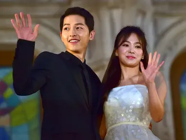 Song Joong Ki dan Song Hye Kyo melambaikan tangan ketika berpose di karpet merah The 52nd Baeksang Art Awards di Seoul, 3 Juni 2016. Melalui agensi masing-masing, Song-Song Couple mengumumkan pernikahan mereka pada 31 Oktober 2017. (JUNG YEON-JE/AFP)