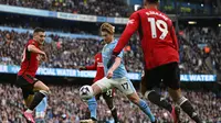 Gelandang Man City, Kevin de Bruyne, dikepung pemain Manchester United saat membawa bola dalam laga pekan ke-27 Liga Inggris 2023/2024 di Etihad Stadium, Minggu (3/3/2024) malam WIB. (Paul ELLIS / AFP)