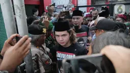 Musikus Ahmad Dhani didampingi Abdul Qodir Jaelani (Dul) melangkah bebas dari LP Cipinang, Jakarta Timur, Senin (30/12/2019). Dhani menghirup udara bebas hari ini setelah menjalani masa hukuman selama 11 bulan di penjara akibat kasus ujaran kebencian. (Liputan6.com/Faizal Fanani)