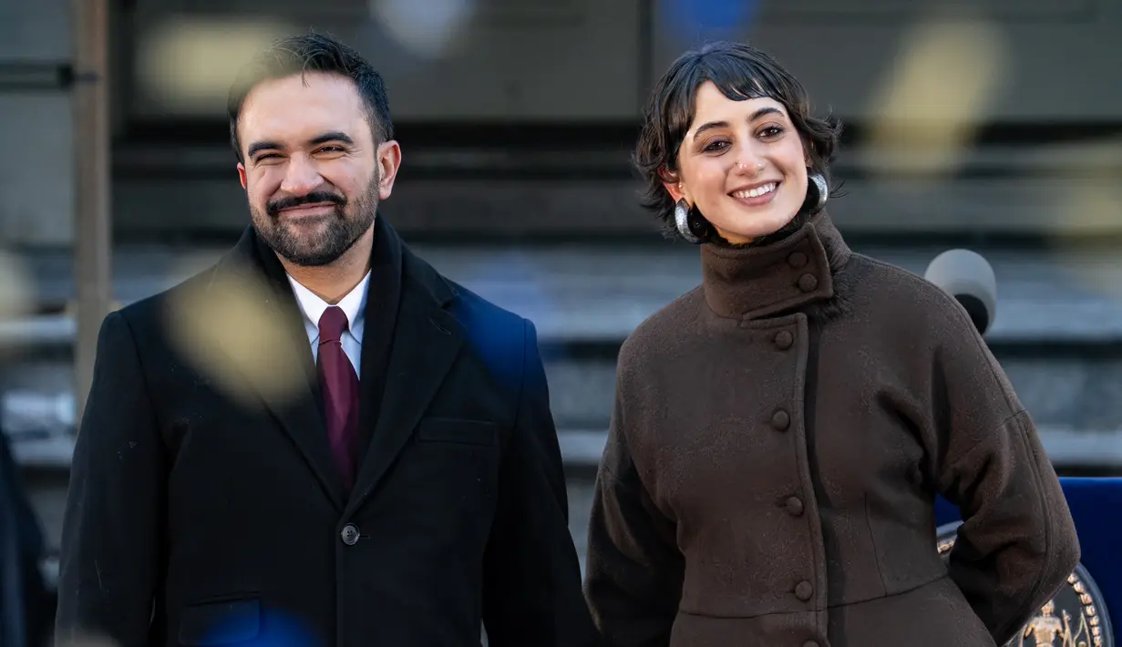 Wali Kota New York City Zohran Mamdani dan istrinya Rama Duwaji tersenyum saat confetti berjatuhan setelah upacara pelantikannya sebagai wali kota di Balai Kota pada Kamis, 1 Januari 2026 di New York, Amerika Serikat. (David Dee Delgado/Getty Images/AFP)