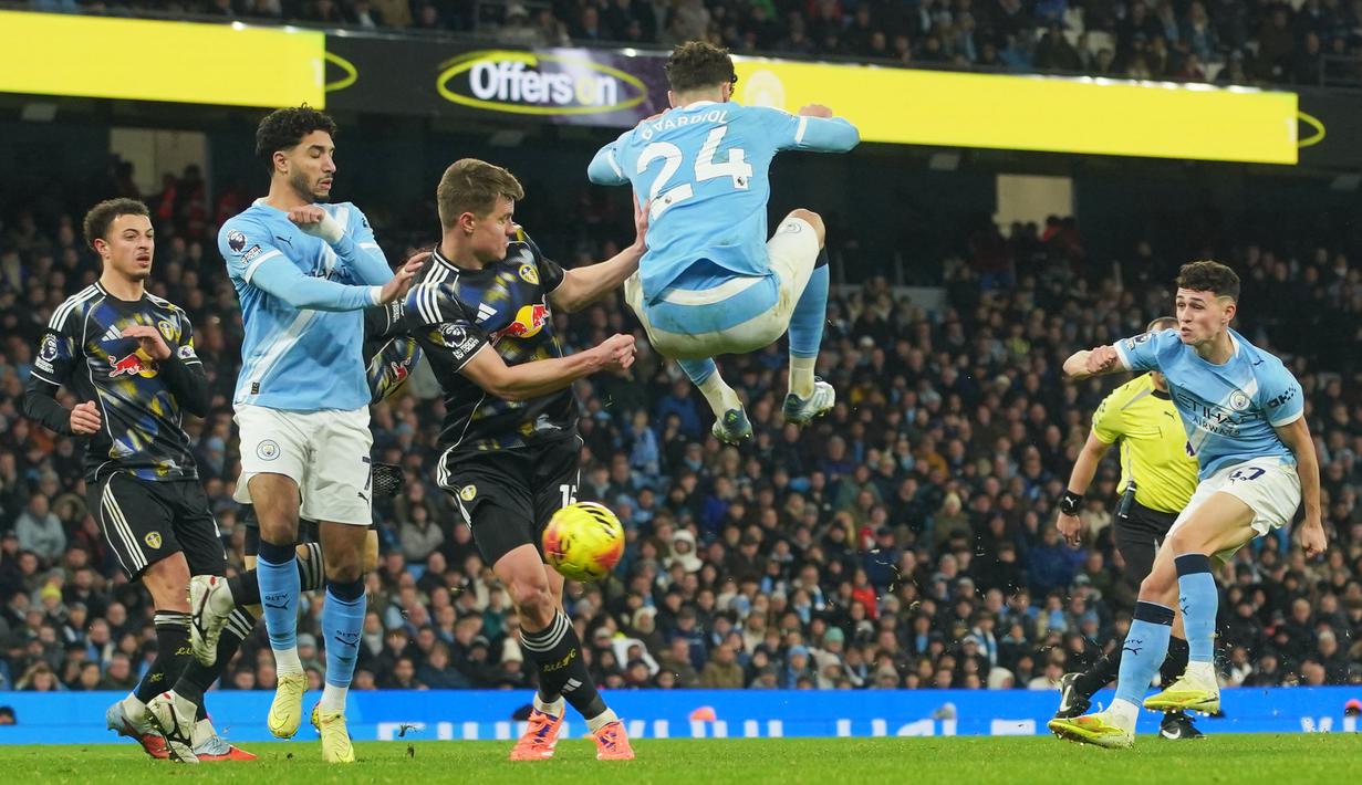 Pemain Manchester City, Josko Gvardiol, melakukan aksi loncat saat Phil Foden melepaskan tendangan ke gawang Leeds United pada pekan ke-13 Premier League 2025/2026 di Etihad Stadium, Sabtu (29/11/2025) malam WIB. (AP Photo/Ian Hodgson)