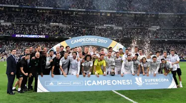 Para pemain Real Madrid berpose dengan trofi merayakan kemenangan atas Barcelona pada Piala Super Spanyol 2017 di stadion Santiago Bernabeu, Spanyol (16/8). Real Madrid menang 2-0 atas Barcelona dengan skor agregat 5-1. (AFP Photo/Javier Soriano)