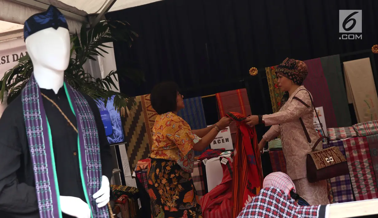 Pengunjung melihat-lihat produk kain tenun yang dipamerkan di Festival Sarung Indonesia 2019, Plaza Tenggara Kompleks GBK, Jakarta, Minggu (3/3). Festival ini diikuti sejumlah perajin sarung tenun dari berbagai daerah. (Liputan6.com/Helmi Fithriansyah)