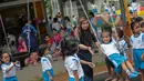 Pendiri Yayasan Pansophia Nusantara, Millie Lukito bermain bersama anak-anak Pendidikan anak usia dini (PAUD) Cahaya Permata Indonesia (CPI) di Rusunawa Marunda, Jakarta Utara, Jumat (30/11). (Liputan6.com/Faizal Fanani)