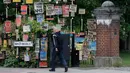 Seorang pria berjalan melewati kumpulan plakat yang dirancang oleh seniman lokal Peter Liversidge untuk mendukung Layanan Kesehatan Nasional (National Health Service/NHS) di London, Inggris, (29/4/2020). (Xinhua/Han Yan)