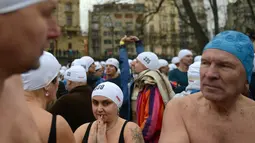 Orang-orang bersiap ambil bagian dalam kompetisi berenang Natal tahunan di sungai Vltava, ibu kota Republik ceko, Praha, Rabu (26/12). Dalam menyemarakkan Natal, para peserta mengikuti lomba renang di sungai bersuhu dingin. (Michal CIZEK / AFP)