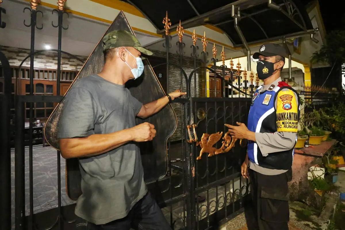 Anggota Binmas Polsek di Surabaya keliling memastikan keamanan rumah warga yang ditinggal mudik. (Dian Kurniawan/Liputan6.com)