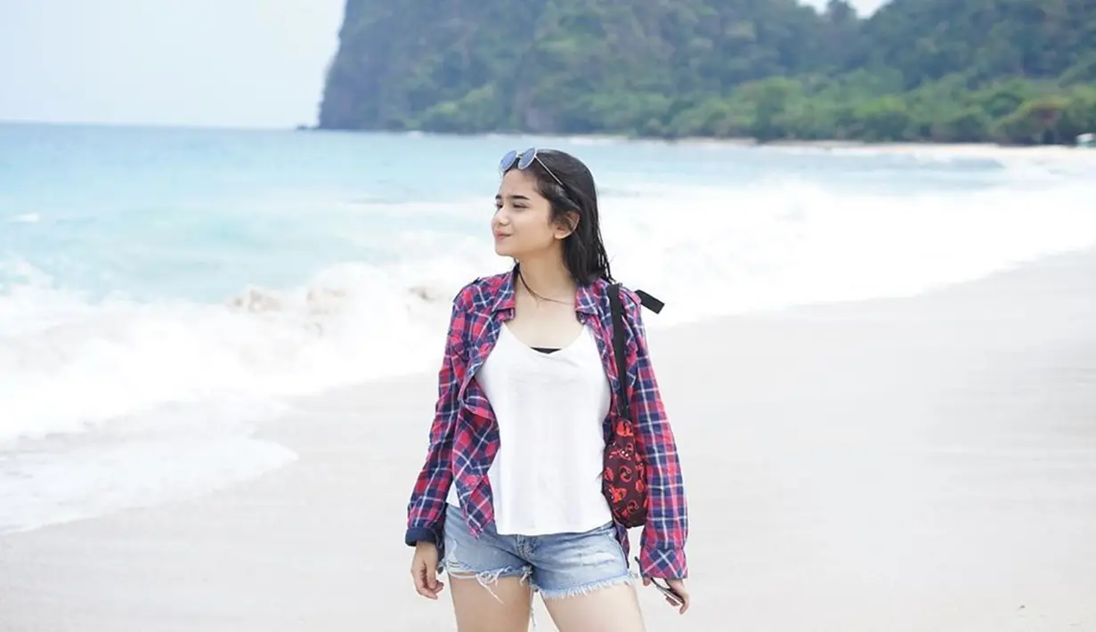 Penampilan Tissa saat tengah berlibur di pantai ini juga bisa ditiru. Ia memilih menggunakan kaus berwarna putih dengan kemeja kotak sebagai outer serta menambahkan kacamata untuk pelengkap. (Liputan6.com/IG/tissabiani)