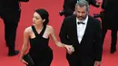 Aktor senior Mel Gibson tampak menggandeng mesra Rosalind Ross saat menaiki tangga karpet merah acara penutupan Festival Film Cannes ke-69 di Prancis, 22 Mei 2016. Pasangan beda usia 35 tahun ini tampak sedang dimabuk asmara. (François Xavier MARIT/AFP)