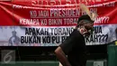 Seorang demonstran berdiri didekat spanduk besar saat berunjuk rasa di depan Kementerian Energi dan Sumber Daya Mineral (ESDM) Jakarta, Selasa (7/3). (Liputan6.com/Johan Tallo)