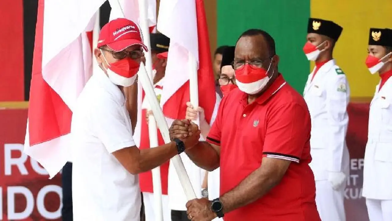 Wakil Menteri Dalam Negeri (Wamendagri) John Wempi Wetipo saat menyerahkan secara simbolis Bendera Merah Putih kepada masyarakat   Aceh, di Tamansari Bustanus Salatin Kota Banda Aceh, Provinsi Aceh, Sabtu, (13/8/2022) (Istimewa)