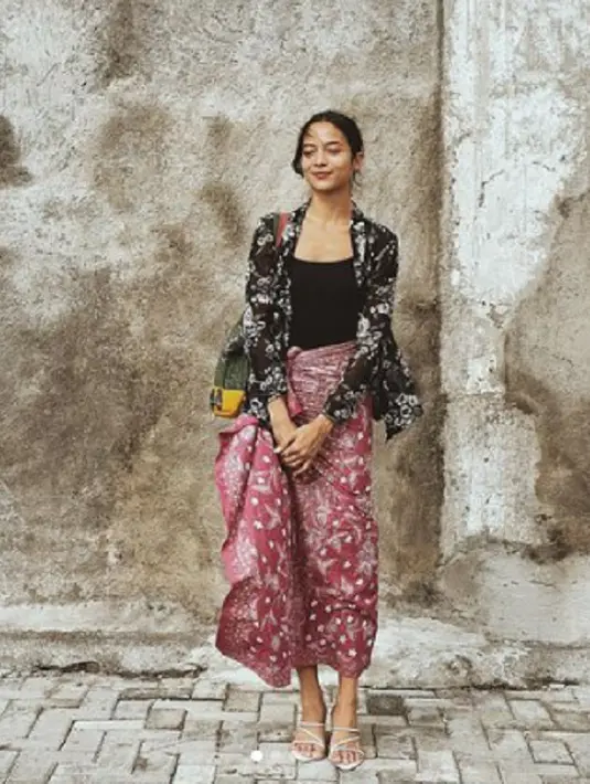Kali ini, lagi dengan kebaya yang tak dikancingkan, Putri Marino terlihat memadukan kebaya hitam bercorak floral dengan kain berwarna merah yang juga bercorak floral. Kesan ramai, tapi tak berlebihan saat Putri Marino tampak mengenakan tank top hitam polos sebagai innerwear dan strappy heels putih. Foto: Instagram.