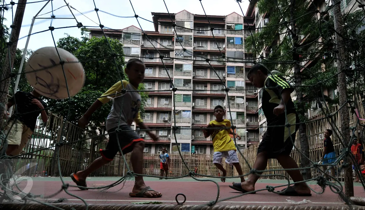 Anak-anak bermain bola di halaman Rusun di Tanah Abang, Jakarta, Senin (4/1/2016). Tahun 2016 Pemprov DKI Jakarta akan membangun 50 rusun bagi warga yang terkena dampak program normalisasi sungai  (Liputan6.com/Johan Tallo)
