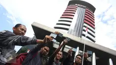 Aktivis Koalisi Masyarakat Sipil menunjukan Kartu Tanda Penduduk (KTP) Elektronik saat melakukan aksi di depan Gedung Komisi Pemberantasan Korupsi (KPK), Jakarta, Minggu (12/3). (Liputan6.com/Immanuel Antonius)