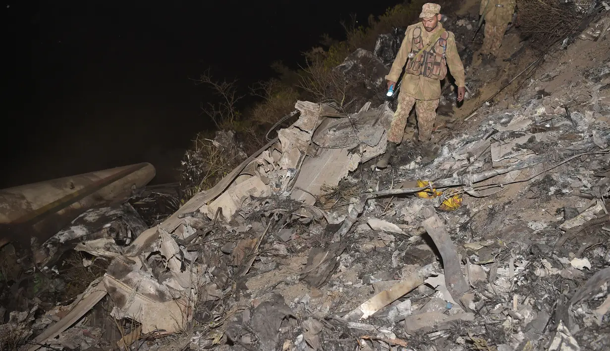 Puing-puing pesawat Pakistan International Airlines (PIA) yang jatuh di Abbottabad, wilayah Khyber Pakhtunkhawa, Rabu (7/12). Penyebab jatuhnya masih belum diketahui tetapi sebuah laporan menyatakan pesawat jatuh akibat kerusakan mesin (AAMIR QURESHI/AFP)
