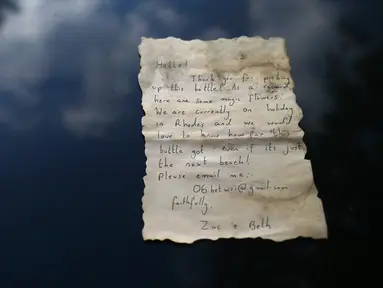 Sebuah kertas berisi pesan yang ditemukan dalam botol oleh nelayan Palestina, Jihad al-Soltan di lepas pantai Jalur Gaza, Selasa (22/8). Pesan itu dilemparkan ke laut oleh pasangan Inggris yang sedang berlibur di Pulau Rhodes, Yunani. (MOHAMMED ABED/AFP)