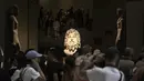 Ratusan turis mengelilingi kepala kolosal dewa Serapis, tengah, salah satu dewa terpenting pada periode Yunani dan Romawi, di museum Mesir di Kairo, Mesir, Rabu, 27 September 2023. (AP Photo/Amr Nabil)
