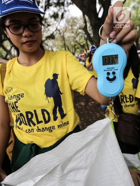Relawan menimbang karung berisi sampah saat gerakan World Cleanup Day 2018 di kawasan Taman Mini Indonesia Indah (TMII), Jakarta, Sabtu (15/9). Gerakan ini bertujuan meningkatkan kesadaran masyarakat untuk menjaga lingkungan. (Liputan6.com/Fery Pradolo)