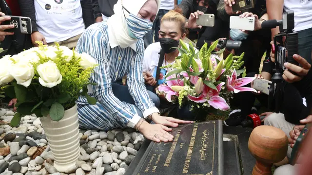Angelina Sondakh ziarah ke makam suaminya Adjie Massaid usai bebas dari penjara. Angie ditemani anak-anaknya. (Kapanlagi.com/Akrom Sukarya)