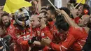 Sebastian Vettel disambut fans dan official tim usai memenangi balapan F1 GP Bahrain di Sirkuit Sakhir, Manama, Minggu (16/4/2017). (AFP/Karim Sahib)