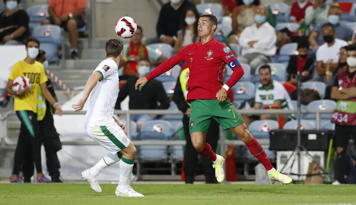 Pemain Portugal Cristiano Ronaldo (kanan) mengontrol bola saat melawan Irlandia pada pertandingan kualifikasi grup A Piala Dunia 2022 di Stadion Algarve, luar Faro, Portugal, Rabu (1/9/2021). Ronaldo mencetak dua gol saat Portugal menang 2-1. (AP Photo/Armando Franca)