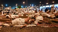 Jemaah haji beristirahat di Muzdalifah, Arab Saudi, Selasa (27/6/2023). Usai melaksanakan wukuf di Arafah, jemaah haji berangkat ke Muzdalifah untuk bermalam. (Sajjad HUSSAIN/AFP)