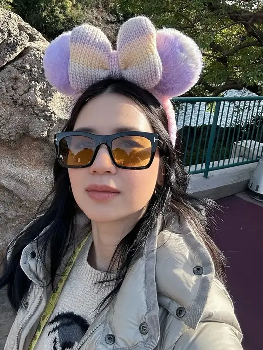 Laura Basuki juga liburan ke Jepang, ia tampil cute dengan bando Minnie Mouse ungu di kepalanya. Ia juga mengenakan sweater coklat serasi dengan outer padding jaketnya. [@laurabas]