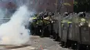 Seorang demonstran melemparkan gas air mata ke arah pasukan polisi di Caracas, Venezuela, (4/4). Mereka menuntut pemerintah menggembalikan kekuasaan kepada pihak opesisi. (AP Photo / Fernando Llano)