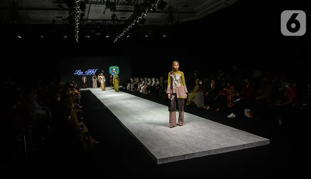 Model membawakan busana kain rancangan karya LIA AFIF fashion desainer berkolaborasi dengan Pemkab Kutai Timur pada Indonesia Fashion Week 2022 di Jakarta Convention Center, Rabu (13/4/2022). Perhelatan Indonesia Fashion Week kembali digelar mulai 13-17 April 2022. (Liputan6.com/JohanTallo)